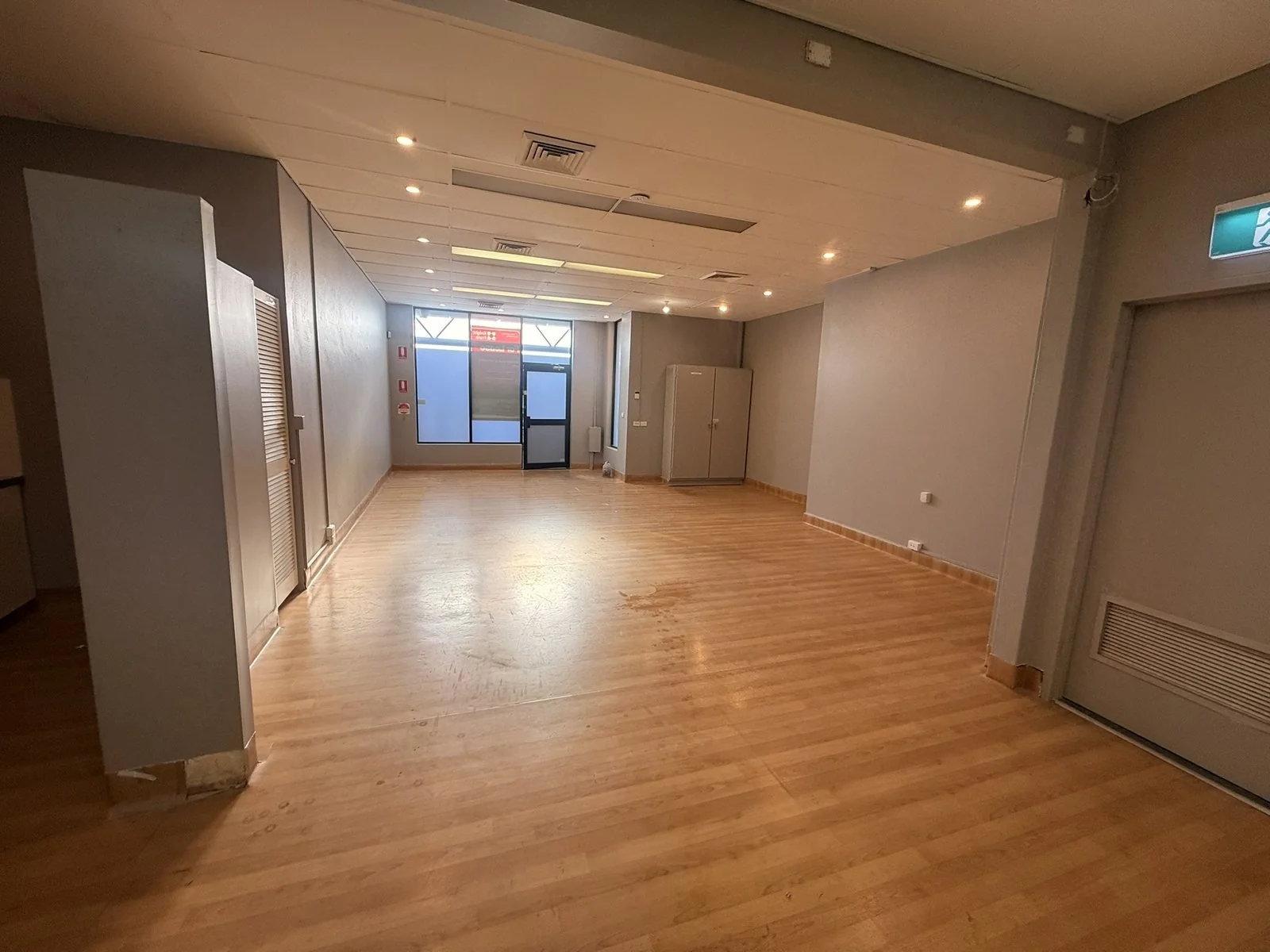 An empty commercial fit-out with freshly painted walls and timber floors