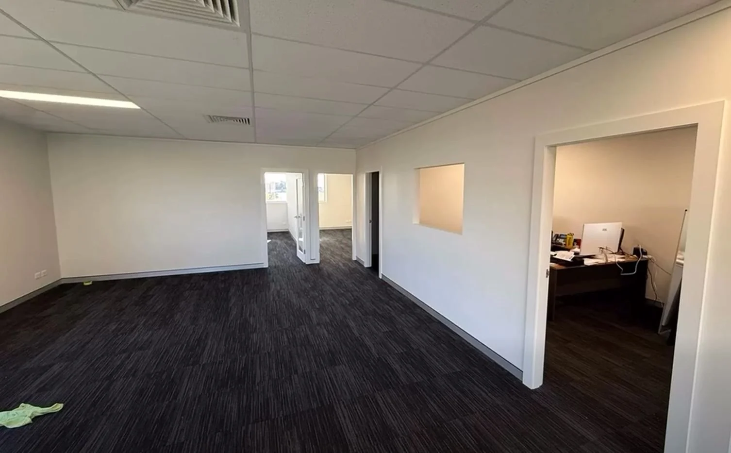 An office painted white with new dark carpet