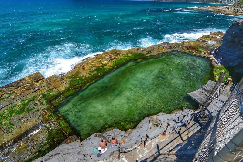 The Bogey Hole from above: a green pool cut into the rock shelf, with the ocean breaking around it